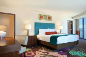 a hotel room with a bed and a desk at Masquerade Tower at Rio Hotel & Casino in Las Vegas