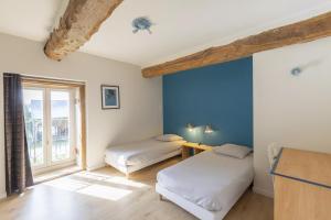 two beds in a room with a blue wall at Le Grand Launay in Pacé +51 photos