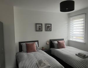 two beds sitting next to each other in a bedroom at 60 Springfield Road in Stornoway