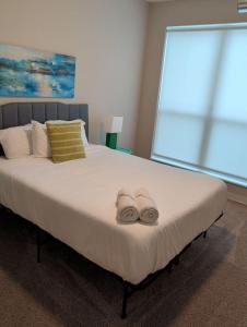 a bedroom with a large bed with towels on it at 4 mi to Jack Thrice Stadium + amenities in Ames