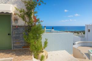a patio with a green door and a view of the ocean at Blue Pulse JR- Villas - Korifi Suites Chersonisos in Heraklio +8 photos