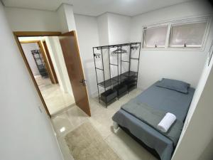 ein kleines Schlafzimmer mit einem Bett und einem Spiegel in der Unterkunft Luxo Urbano 1 suítes mais 2 quartos in Campinas + 29 Fotos