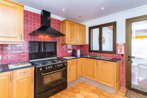 une cuisine avec des armoires en bois et un four à plaques de cuisson dans l'établissement Casa Honiol, private and spacious villa with sea views, à Cala'n Porter