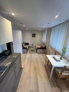 a kitchen and living room with a table and a couch at Your Private Apartment in Vibrant Wembley! in London
