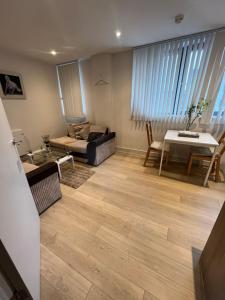a living room with a couch and a table at Your Private Apartment in Vibrant Wembley! in London +2 photos