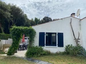 een wit huis met blauwe deuren en een patio bij Maison Vert d'Eau in Grand-Village-Plage +18 foto's