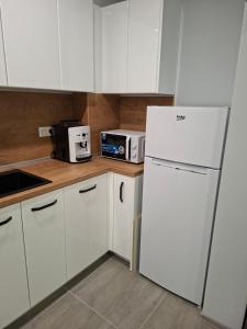a kitchen with white cabinets and a white refrigerator at Number 1 in Ruse +11 photos