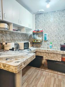 eine Küche mit weißen Schränken und Marmorarbeitsflächen in der Unterkunft Balai Hermioni in San Pablo City