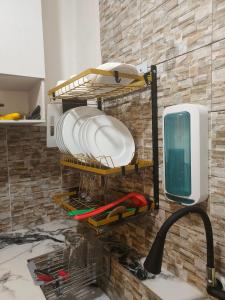 eine Küchenspüle mit Tellern an der Wand in der Unterkunft Balai Hermioni in San Pablo City