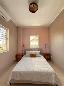 Dormitorio con cama con almohada amarilla en Breezy Azul Getaway, en Willemstad
