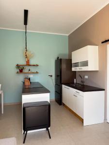 cocina con armarios blancos y encimera negra en Breezy Azul Getaway, en Willemstad