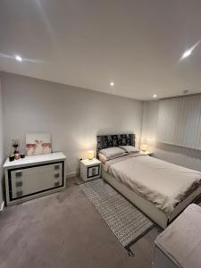 a bedroom with two beds and two night stands at Your Private Apartment in Vibrant Wembley! in London