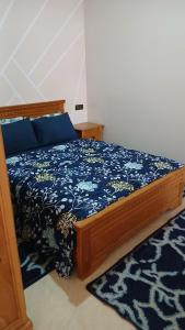 Un dormitorio con una cama con un edredón azul. en Appartement, en Chichaoua