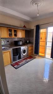 Una cocina con lavadora y secadora en una habitación. en Appartement, en Chichaoua