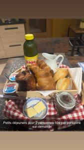 una mesa con una bandeja de pasteles y una botella de intendente en Le Merisier, 