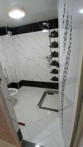 Un baño con ducha de cristal con inodoro. en Appartement, en Chichaoua