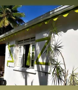 a white house with palm trees in front of it at Résidence Fleur de Café in Lamentin