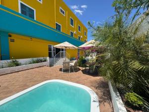 a swimming pool in front of a yellow building at Pousada Serra Bella in Tianguá
