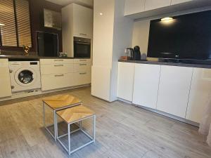 eine Küche mit einem Fernseher auf der Arbeitsplatte und einem Tisch in der Unterkunft Appartement entier T2 proche gare de Cergy préfecture in Cergy + 4 Fotos