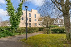 ein Straßenlicht im Gras vor einem Gebäude in der Unterkunft Appartement entier T2 proche gare de Cergy préfecture in Cergy