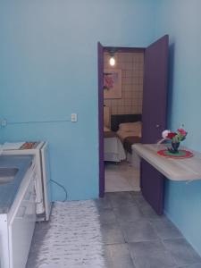 a room with a blue wall and a room with a kitchen at apartamento 301 in Florianópolis