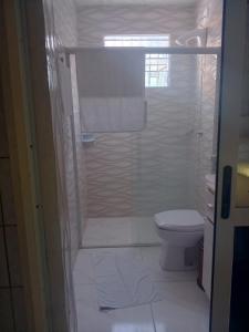 a white bathroom with a toilet and a shower at apartamento 301 in Florianópolis