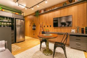 uma cozinha com uma mesa, um frigorífico e um balcão em SSG - Estúdios próximos a UFSC em Florianópolis em Florianópolis