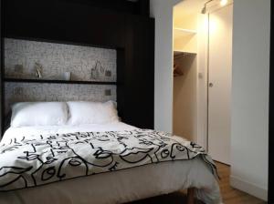 a bedroom with a bed with a black and white comforter at Appartement Paccard, Centre Ville in Chamonix-Mont-Blanc
