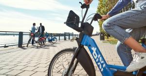 a woman riding a blue bike on a pier at McGill Les petits studios in Montréal