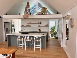 a kitchen with a large island with bar stools at Capri House in Clareville