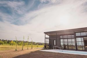 a building with a swimming pool next to a field at Carmelo Golf by Puerto Dijama in Colonia Estrella