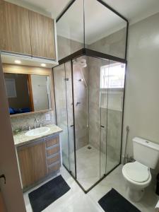 um banheiro com chuveiro, vaso sanitário e pia em Duas Suites aconchegantes em frente a Montanha em Poços de Caldas mais 34 fotografias