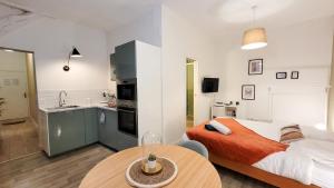 une chambre avec un lit et une table et une cuisine dans l'établissement L'Eden Rouennais - Gare de Rouen, à Rouen