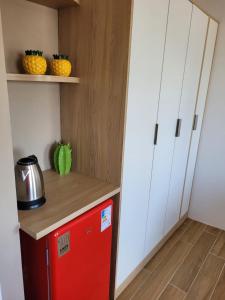 a red refrigerator in a kitchen with white cabinets at Carambola CoLiving in Olinda +24 photos