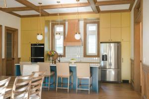 een keuken met een tafel, stoelen en een koelkast bij Samson House in Revelstoke