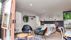 ein Schlafzimmer mit einem Bett und einem Tisch und Stühlen in der Unterkunft Picton Paradise Cottages in Picton