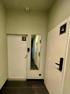 a hallway with two white doors and a mirror at KWADRAT hostel 