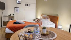 a bedroom with a table with a basket of bread at L'Eden Rouennais - Gare de Rouen in Rouen