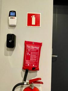 a fire extinguisher and a cell phone on a wall at KWADRAT hostel  +14 photos