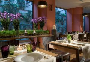 a restaurant with tables and chairs with purple flowers at Starhotels Tuscany in Florence