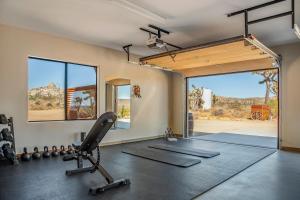 a room with a gym with a treadmill and a mirror at Salt Pool - Sauna - Cold Plunge - Lux Desert Ranch in Pioneertown