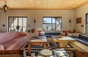 a living room with a couch and a table at Salt Pool - Sauna - Cold Plunge - Lux Desert Ranch in Pioneertown