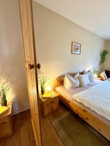 a bedroom with a bed with white sheets and pillows at BAUERNHAUS KRULL App 03 in Althagen