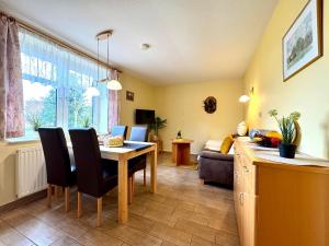a kitchen and living room with a table and chairs at BAUERNHAUS KRULL App 03 in Althagen