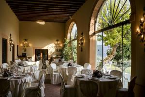 a dining room with white tables and chairs and windows at Villa Michelangelo Vicenza – Starhotels Collezione in Arcugnano
