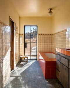 a bathroom with a tub and a window at Salt Pool - Sauna - Cold Plunge - Lux Desert Ranch in Pioneertown
