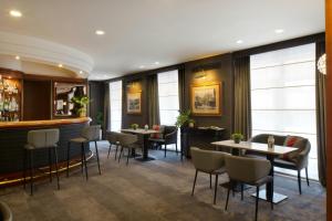 a restaurant with tables and chairs and a bar at Starhotels Tourist in Milan