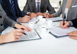 Un groupe de personnes assises autour d'une table avec des ordinateurs portables dans l'établissement A la Grenouille du Jura, à Bellignat