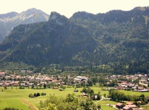 un pueblo en un valle con montañas al fondo en Gemütliche Ferienwohnung In Unterammergau, en Unterammergau
