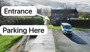 a white van parked in a driveway with the words entrance parking here at Lincoln Cathedral Retreat in Scampton